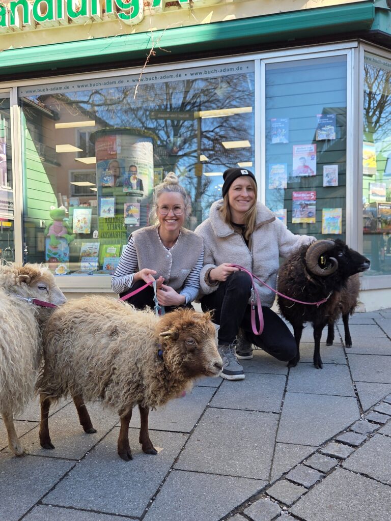 Die Autorinnen von "Die krasseste Herde" mit ihren Schafen vor der Buchhandlung Adam in Garmisch-Partenkirchen (Foto: privat)