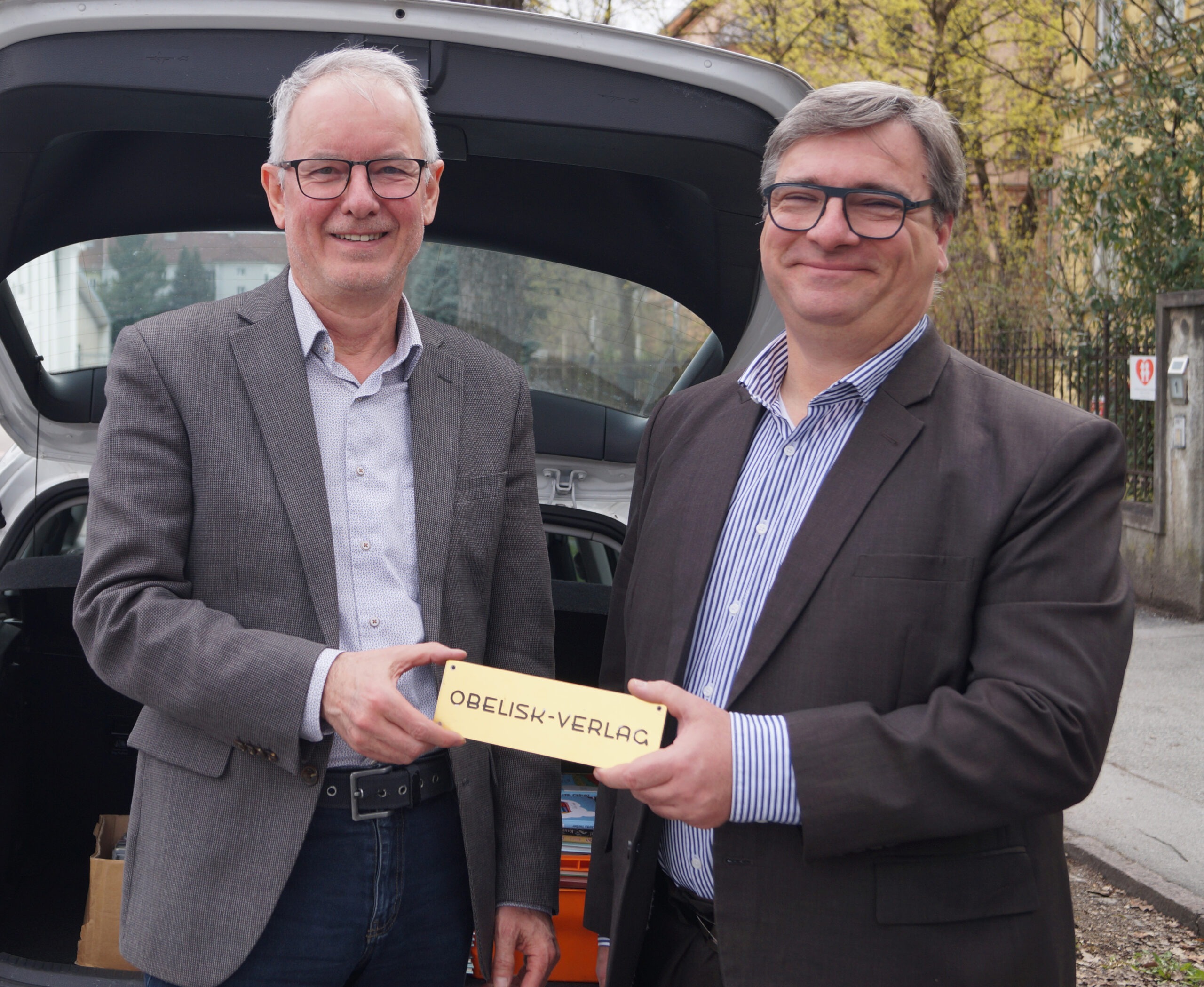 Mag. Gottfried Kompatscher und Ing. Markus Buchroithner freuen sich, dass das Obelisk-Firmenschild an die Tyrolia weitergegeben werden kann. (Foto: Tyrolia)