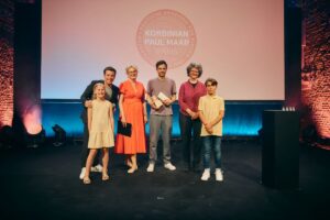 Korbinian-Preisträger Jona Manow (Mitte) mit Moderator Benedikt Weber, Akademiepräsidentin Dr. Claudia Maria Pecher, Anne Maar und den Leseluchs-Kindern Hannah Seuffert und Fabian Kaiser (v. l.) beim Paul Maar-Preis 2026 (Foto: Andreas Fuchs / Bayernwerk AG)